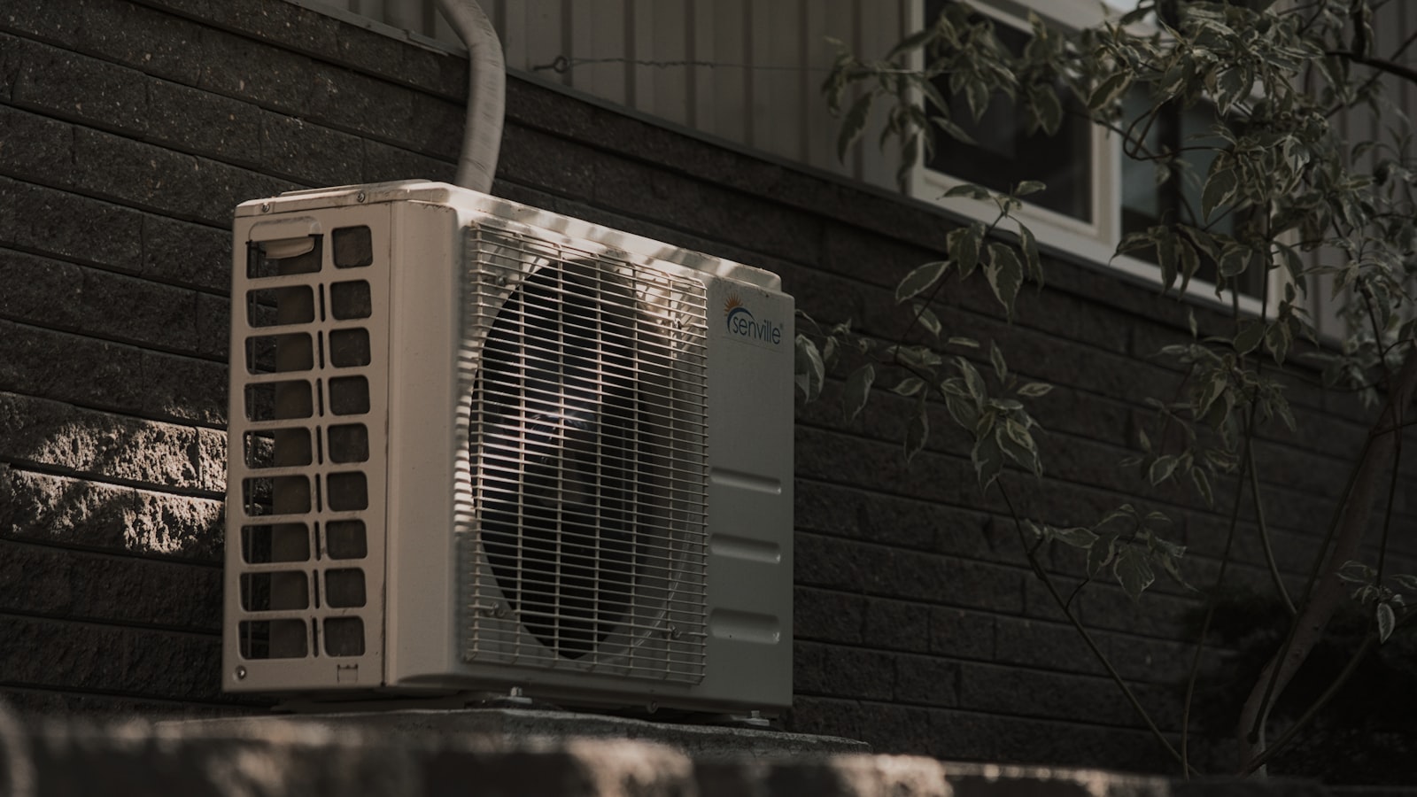 Air conditioning unit installed on exterior wall of a home